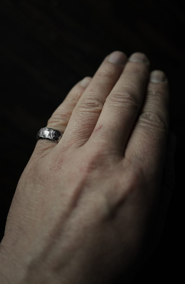 Hand with hammered silver ring on - product shoot.