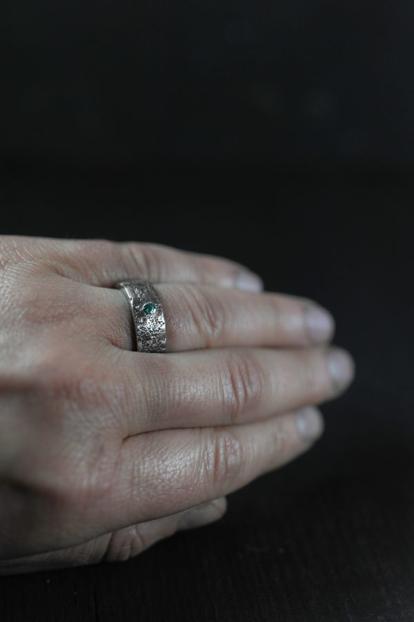 Pictured with a green moissanite ring on her finger.